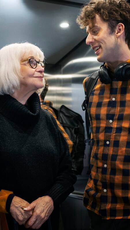 img_young-man-and-older-lady-in-residential-builings-elevator-450x800